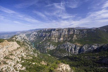 Verdon nehri derin kanyonda kıvrılıyor, çevresi kireçtaşı kayalıkları ve yeşil bitki örtüsüyle çevrili.