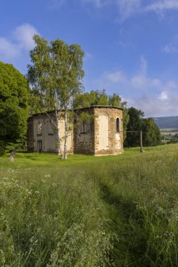Mavi gökyüzünün altında, köhne bir kilisede çürümeyi ve unutulmuş tarihi sembolize ediyor.