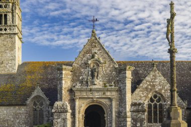 Bulutlu mavi gökyüzüne karşı duran antik taş şapel ve heykel