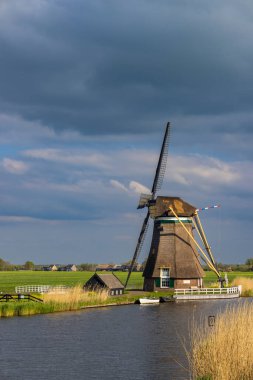 Hollanda, Güney Hollanda 'daki Ammerse Kade boyunca bulutlu bir gökyüzüne karşı tarihi yel değirmeni