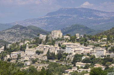 Montbrun les Bains tepesindeki ortaçağ köyü tarihi mimariyi ve çevresindeki manzarayı gösteriyor.