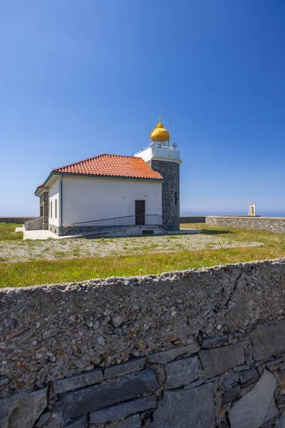 Cudillero, İspanya 'da açık mavi gökyüzünün altında parlak sarı kubbeli deniz feneri yapısı