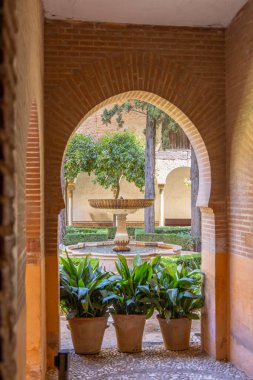 Mağripli kemer, tarihi bahçe avlusunu merkez çeşme ve saksı bitkileriyle süslüyor.