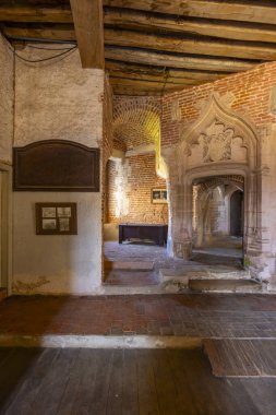 Eski duvarlar, yıpranmış döşemeler ve Saint Fargeau 'da süslü oyulmuş bir kapı.