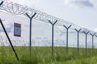 Ustura teli ve güvenlik çiti. Yasak bölge işaretli.
