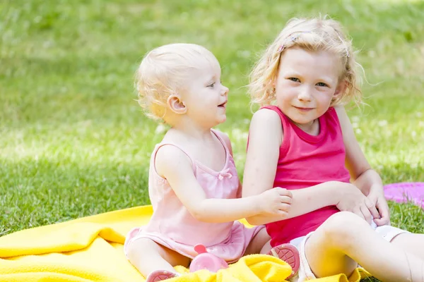 Little girls sitting on blanket — Stock Photo, Image