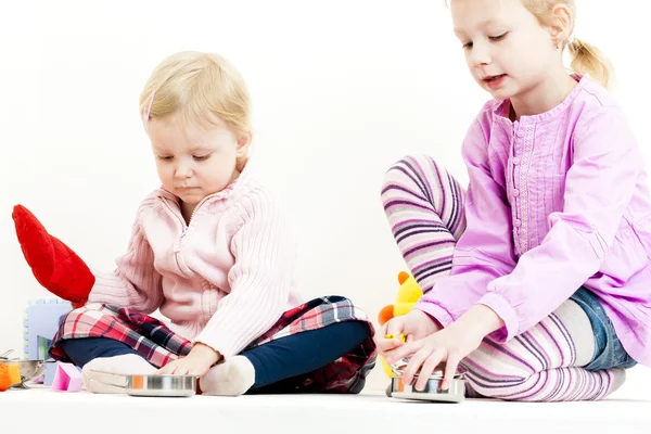 Two little girls playing with child dish — Stock Photo, Image