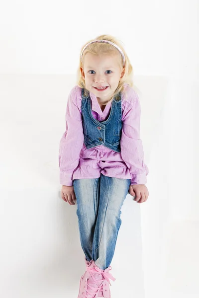 Sitter lilla flicka klädd i jeans — Stockfoto
