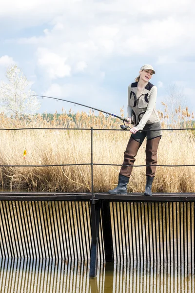 Nő, horgászat a mólón a tó — Stock Fotó