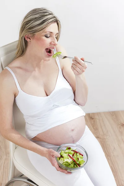 Retrato de mulher grávida comendo salada de legumes — Fotografia de Stock