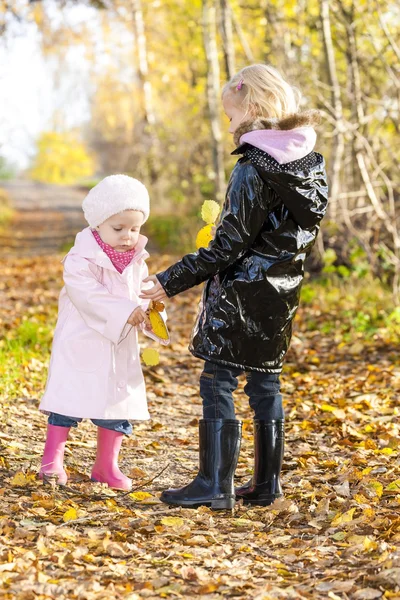 Little girls wearing rubber boots in autumnal nature — Stock Photo, Image