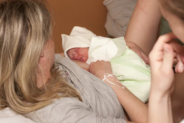 Chupando de um bebê recém-nascido após o parto — Fotografia de Stock