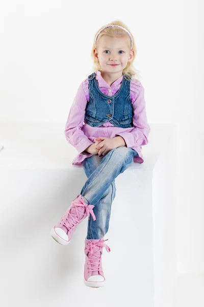 Seduta bambina indossando jeans — Foto Stock