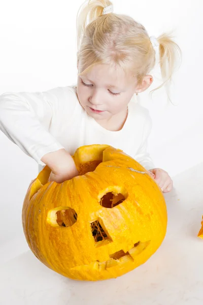 Liten flicka snidning pumpa till halloween — Stockfoto