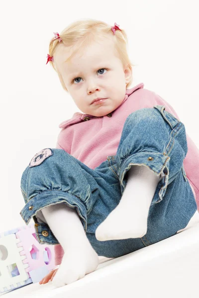 Сидяча маленька дівчинка в джинсах — стокове фото