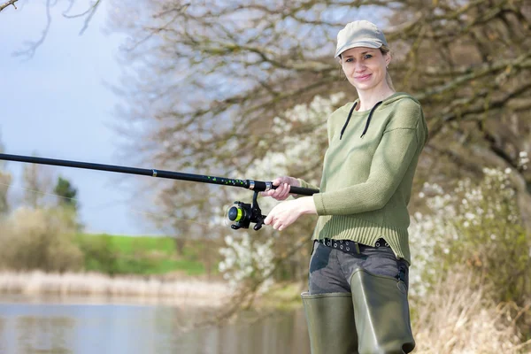 Mulher pesca na lagoa na primavera — Fotografia de Stock