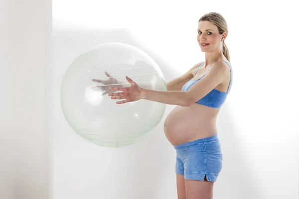 Těhotná žena dělá cvičení s míčem — Stock fotografie