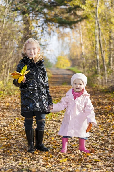 Små flickor bär gummistövlar i höstliga naturen — Stockfoto