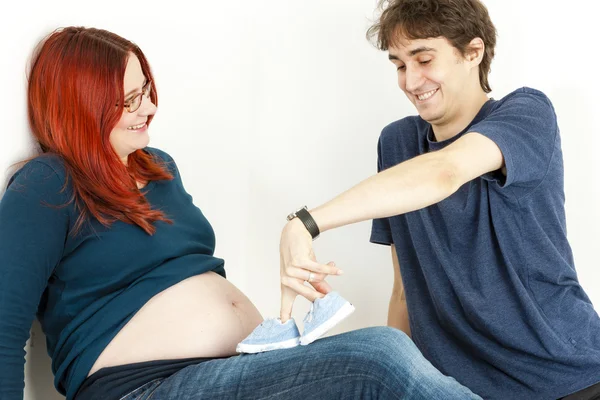 Donna incinta e suo marito con le scarpe per un bambino — Foto Stock