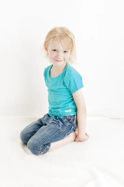 Сидящая маленькая девочка — стоковое фото