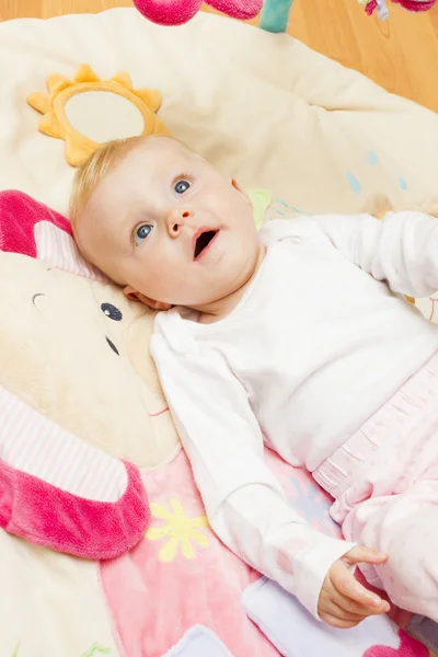 Baby flicka liggande på spelar matta — Stockfoto