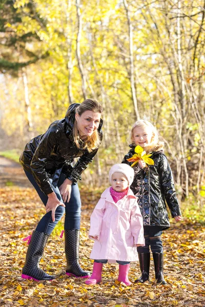 Mamma med hennes döttrar i höstliga naturen — Stockfoto