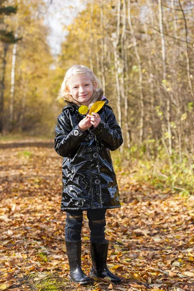 Meisje het dragen van rubberen laarzen in de herfst natuur — Stockfoto