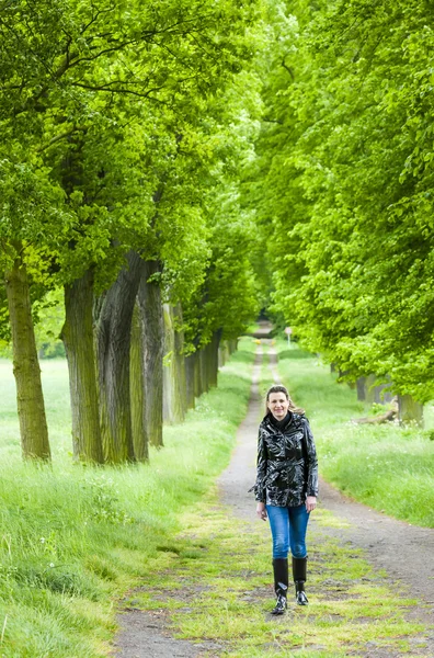 Donna che indossa stivali di gomma che cammina nel vicolo primavera — Foto Stock