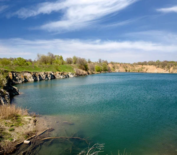 Lago roky bajo el cielo agradable con nubes — Foto de Stock