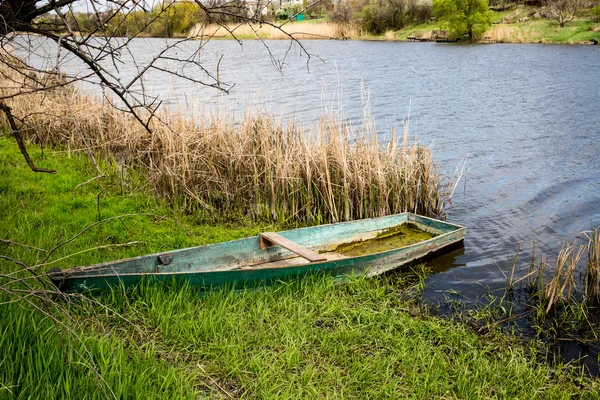 Wooden boat on river shore — Stock Photo, Image