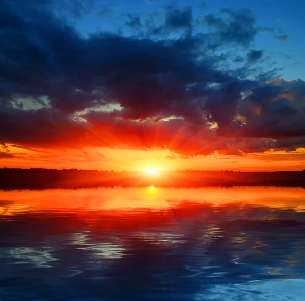 Pôr do sol sobre a superfície da água — Fotografia de Stock