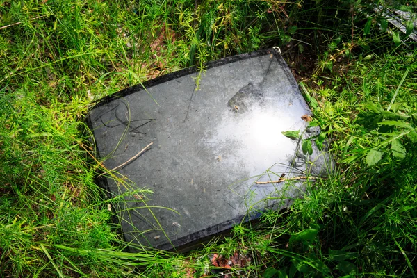 Broken television tube in green grass — Stock Photo, Image
