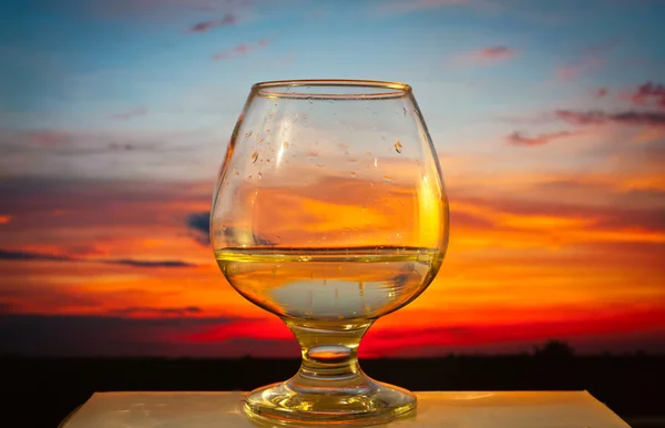 Glas med vatten på sunset bakgrund — Stockfoto