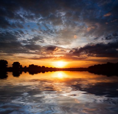 Su yüzeyinde güzel bir günbatımı gökyüzü