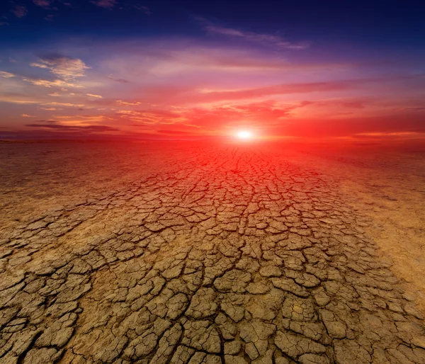 Por do sol sobre terra rachada — Fotografia de Stock