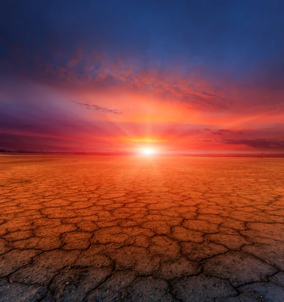 Tierra agrietada y puesta de sol — Foto de Stock