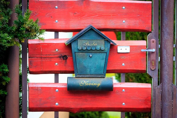 Post box on red wooden gate — Stock Photo, Image