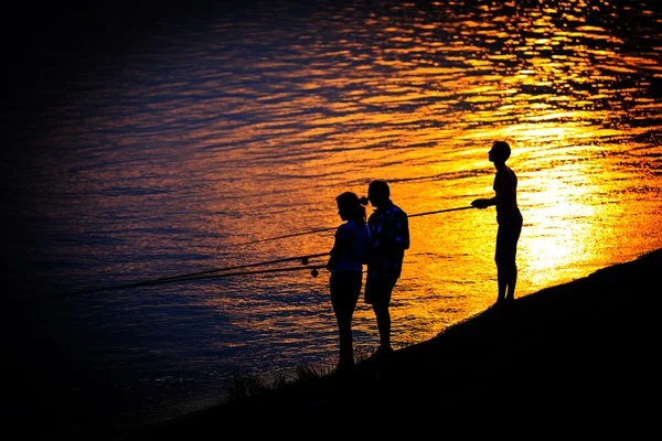 Figuras de pescador abstratas contra o fundo do pôr do sol — Fotografia de Stock