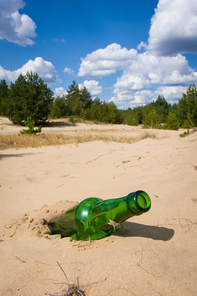 Botella verde en arena — Foto de Stock