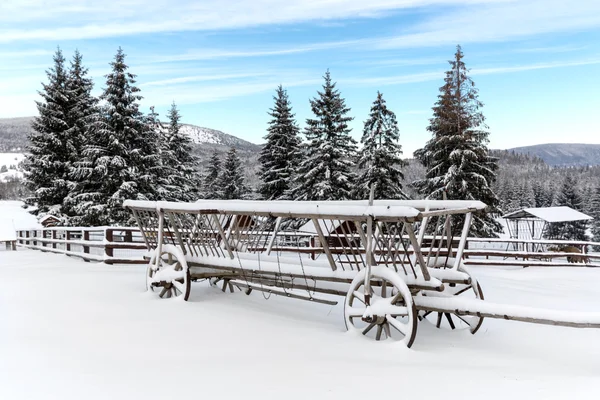 Velha carruagem de madeira na neve — Fotografia de Stock