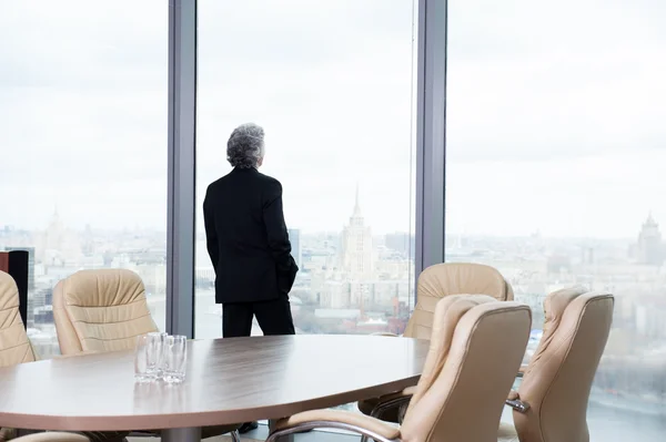 Hombre de negocios de mediana edad mirando por la ventana —  Fotos de Stock