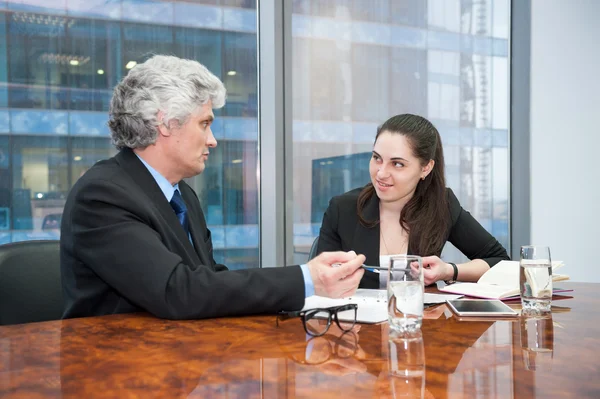 Зрелый бизнесмен и молодая деловая женщина обсуждают — стоковое фото