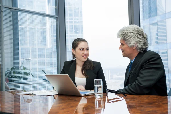 Reifer Geschäftsmann und junge Geschäftsfrau diskutieren — Stockfoto