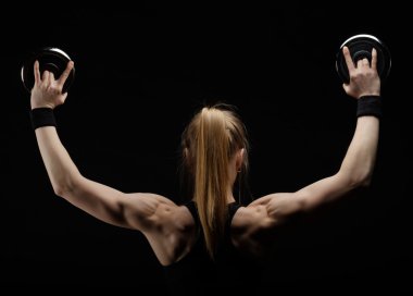 Genç ince güçlü kas kadın dumbbell ile studio poz 