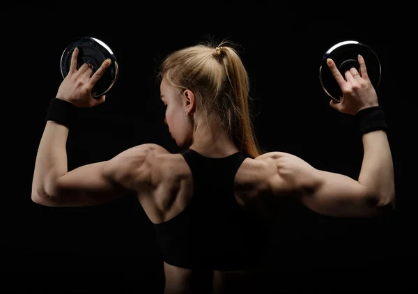 Young slim strong muscular woman posing in studio with dumbbell — Stock Photo, Image