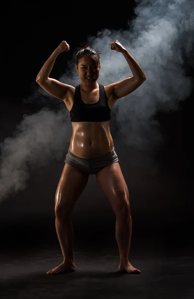 Jovem muscular mulher posando no preto — Fotografia de Stock