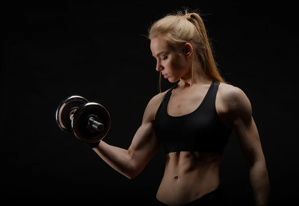Young slim strong muscular woman posing in studio with dumbbell — Stock Photo, Image