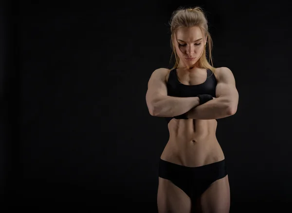 Jovem muscular mulher posando no preto — Fotografia de Stock