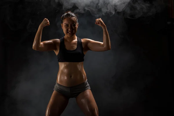 Young muscular woman posing on black — Stock Photo, Image