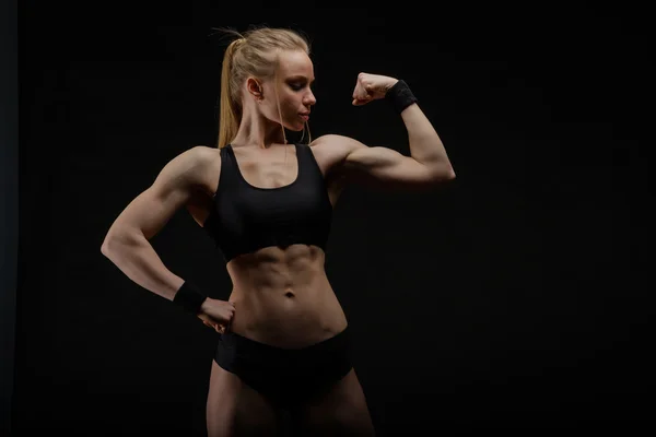 Junge muskulöse Frau posiert auf schwarz — Stockfoto